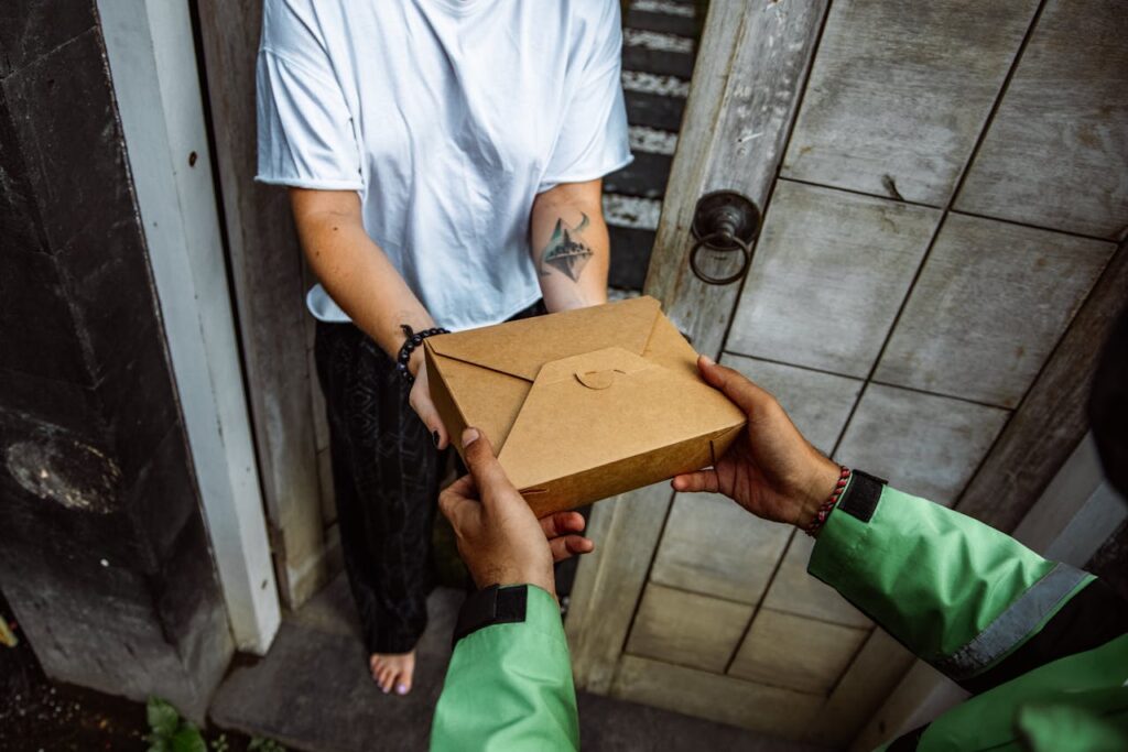 A delivery person handing over a package to a customer at their doorstep.