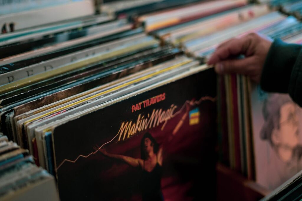 Person browsing vinyl records collection in a Cambridge store. Nostalgic and retro vibe.